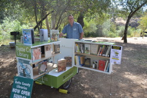 Outreach coordinator, Oliver Allen, stands proudly next to the Butte County BookBike, which the Chico Friends of the Library donated $500 towards. 